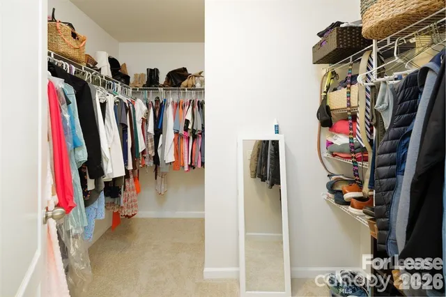 a view of walk in closet with clothes and shoes