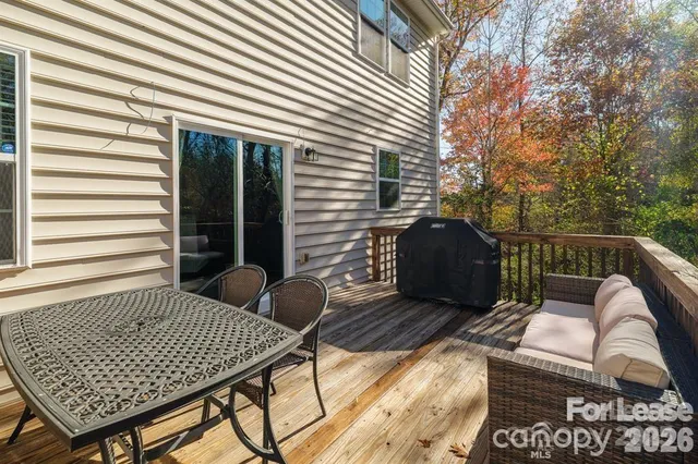 a view of a patio with table and chairs with wooden floor and fence