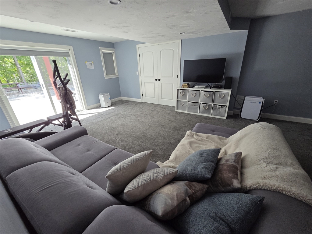11 Millies Way, Unit 11 Sterling, MA 01564 - Photo 22 of 28 a living room with furniture and a flat screen tv