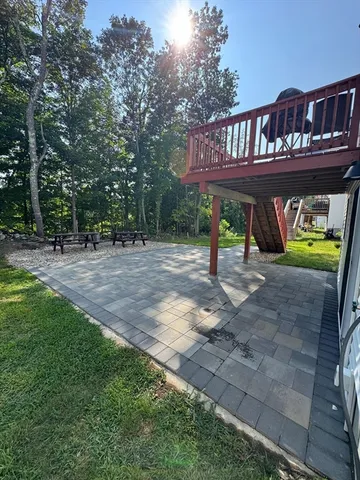 a view of swimming pool with lawn chairs and plants