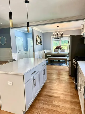 a kitchen with kitchen island granite countertop a sink appliances and cabinets