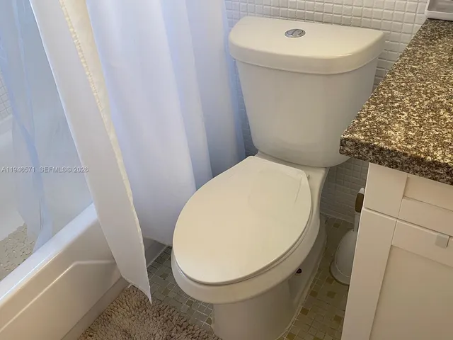a white toilet sitting next to a white sink