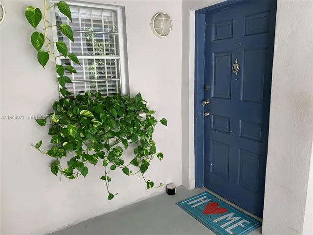a vase with flowers sitting on a floor in front of a door