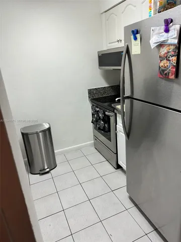 a kitchen with a refrigerator and a stove top oven
