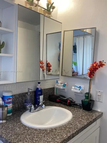 a bathroom with a granite countertop sink and a mirror
