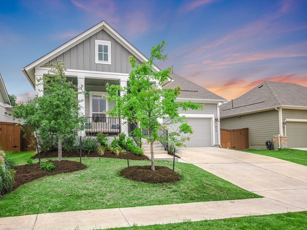 a front view of a house with a yard and potted plants