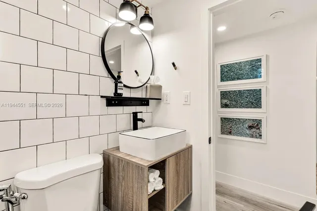 a bathroom with a sink a toilet and a mirror