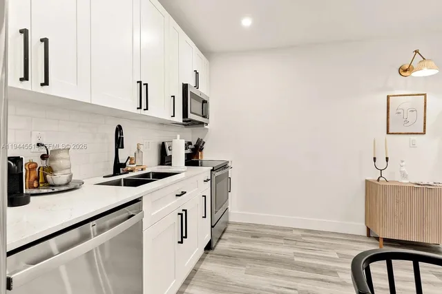 a kitchen with stainless steel appliances a sink a stove a refrigerator and cabinets