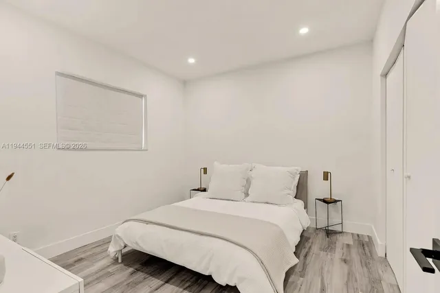 a bedroom with a bed and a wooden floor