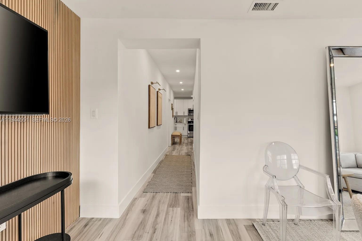 1237 Northwest 33rd Avenue, Unit 1 Miami, FL 33125 - Photo 3 of 22 a view of a hallway with wooden floor and staircase