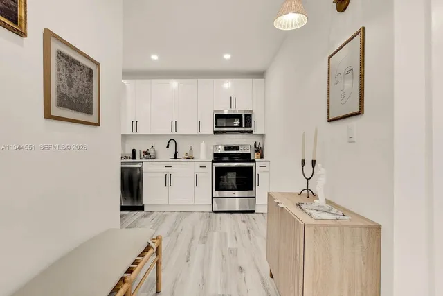 a kitchen with stainless steel appliances a refrigerator and a stove top oven