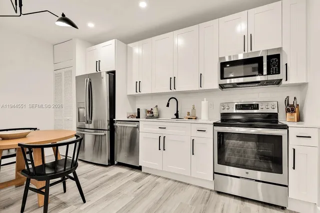 a kitchen with stainless steel appliances a stove a sink island and a refrigerator