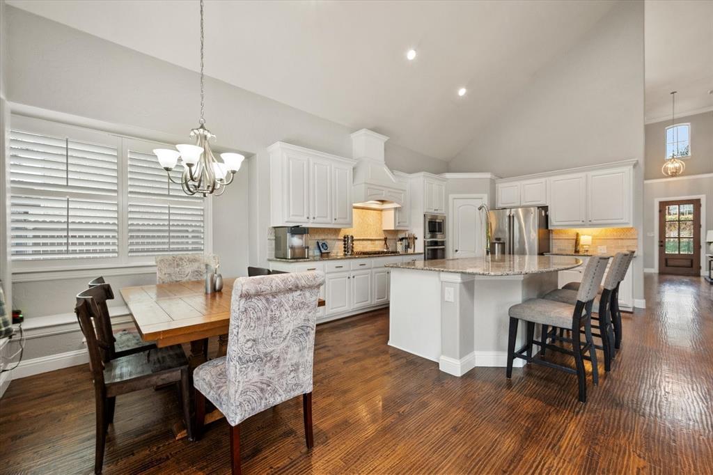 6713 Matador Ranch Road North Richland Hills, TX 76182 - Photo 12 of 39 Kitchen with hanging lights, vaulted ceiling, a breakfast bar area, a kitchen island, and granite counters