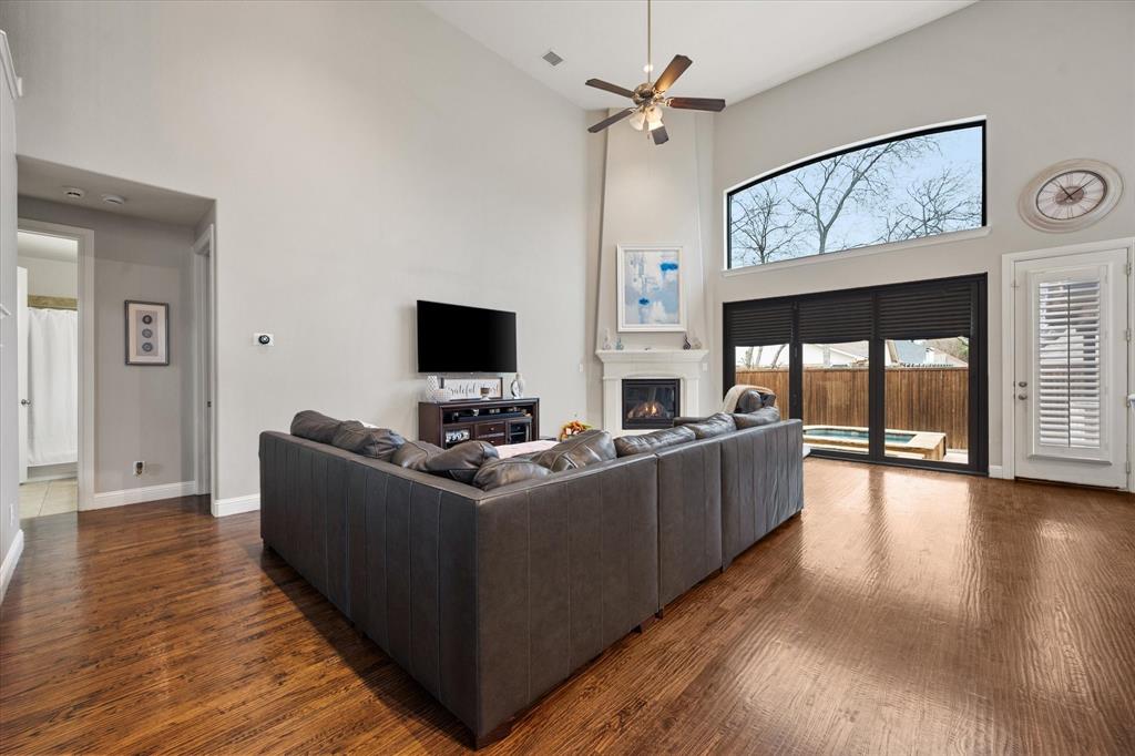 6713 Matador Ranch Road North Richland Hills, TX 76182 - Photo 17 of 39 Living area with a high ceiling, dark wood finished floors, a ceiling fan, and a glass covered fireplace