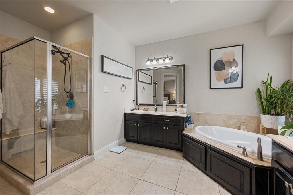 6713 Matador Ranch Road North Richland Hills, TX 76182 - Photo 21 of 39 Bathroom featuring a bath, vanity, a stall shower, and light tile patterned flooring