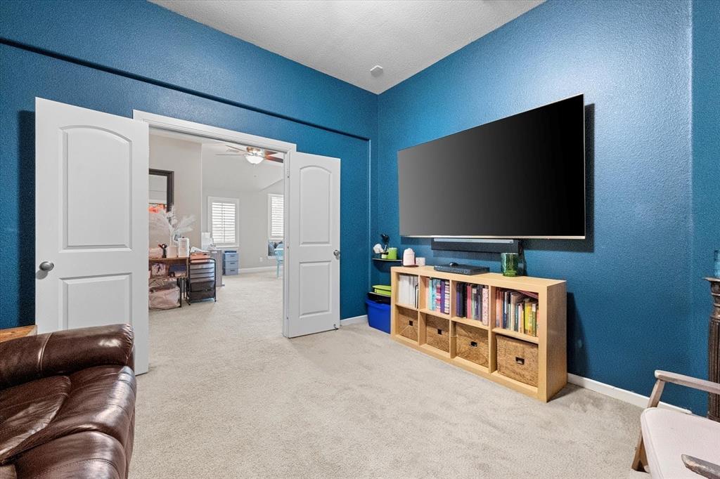 6713 Matador Ranch Road North Richland Hills, TX 76182 - Photo 27 of 39 Carpeted living area with a textured wall and ceiling fan