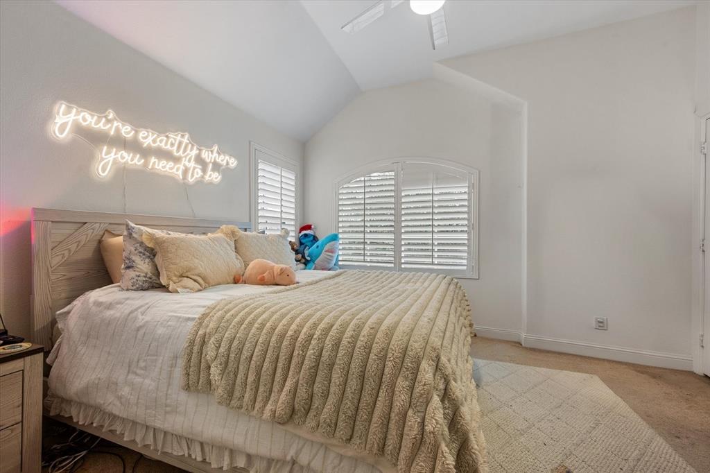 6713 Matador Ranch Road North Richland Hills, TX 76182 - Photo 32 of 39 Bedroom featuring light colored carpet, vaulted ceiling, and ceiling fan
