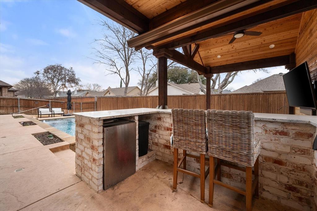 6713 Matador Ranch Road North Richland Hills, TX 76182 - Photo 35 of 39 Fenced backyard with an outdoor kitchen, a patio area, TV and ceiling fan