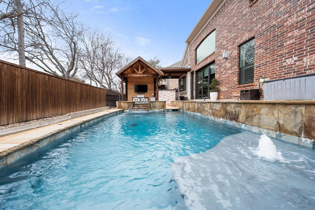 6713 Matador Ranch Road North Richland Hills, TX 76182 - Photo 36 of 39 View of swimming pool featuring exterior fireplace, a fenced backyard, and patio surround