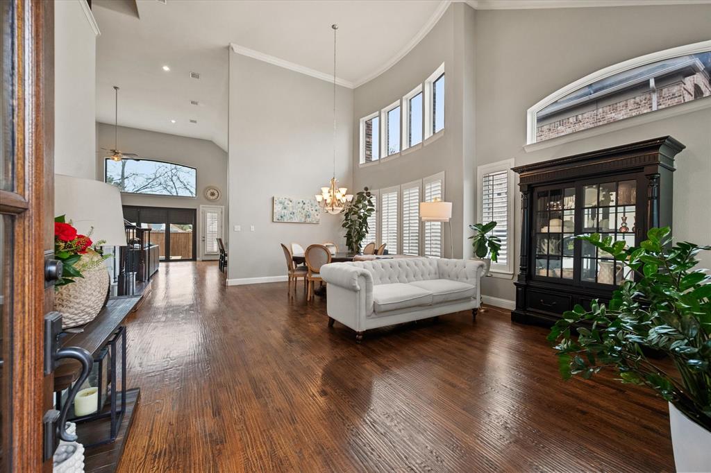 6713 Matador Ranch Road North Richland Hills, TX 76182 - Photo 5 of 39 Living room featuring a high ceiling, wood-style floors, crown molding, a chandelier, and a ceiling fan