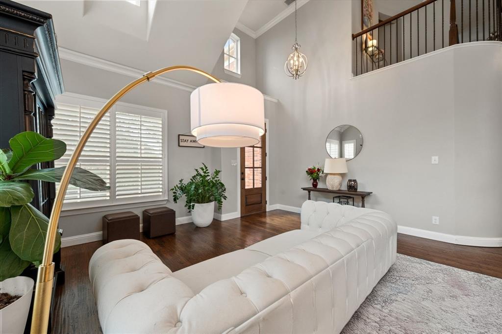 6713 Matador Ranch Road North Richland Hills, TX 76182 - Photo 6 of 39 Living area with a high ceiling, plenty of natural light, dark wood finished floors, crown molding, and a chandelier