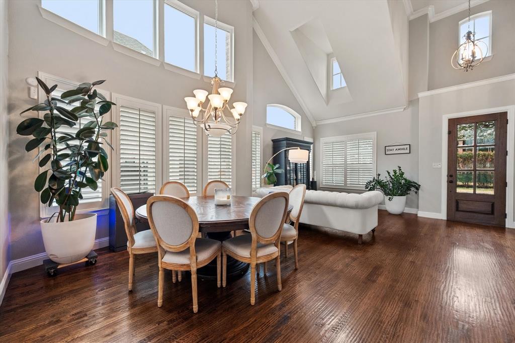 6713 Matador Ranch Road North Richland Hills, TX 76182 - Photo 7 of 39 Dining space featuring a chandelier, wood-type flooring, a high ceiling, and ornamental molding
