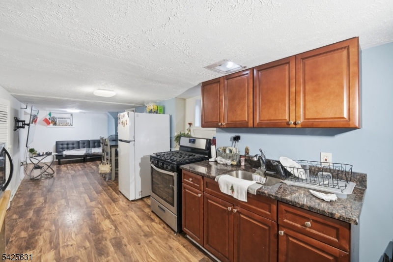 60 Westervelt Place Lodi, NJ 07644 - Photo 30 of 48 a kitchen with stainless steel appliances granite countertop a sink stove and cabinets