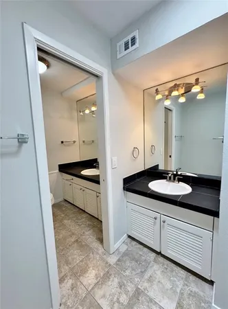 a bathroom with a granite countertop sink a mirror and a vanity