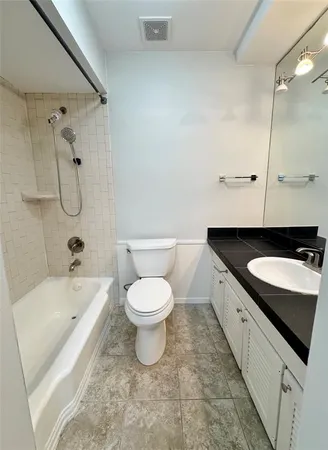 a bathroom with a granite countertop sink a toilet and bathtub