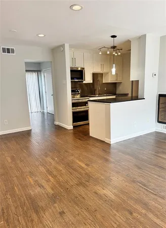 a large kitchen with stainless steel appliances granite countertop a stove a sink and a refrigerator