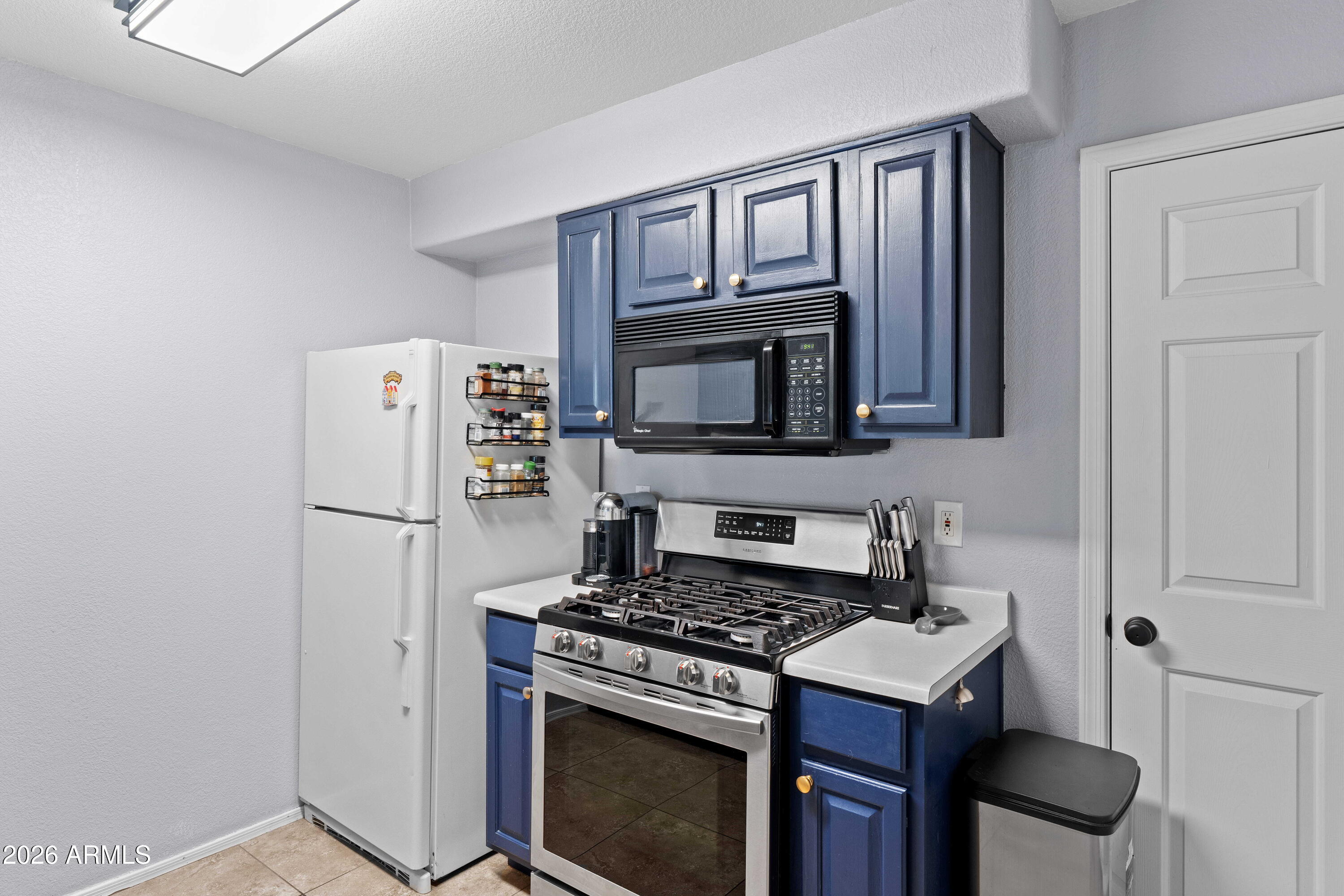 1505 North Center Street, Unit 115 Mesa, AZ 85201 - Photo 11 of 24 a kitchen with stainless steel appliances a stove a microwave and a refrigerator