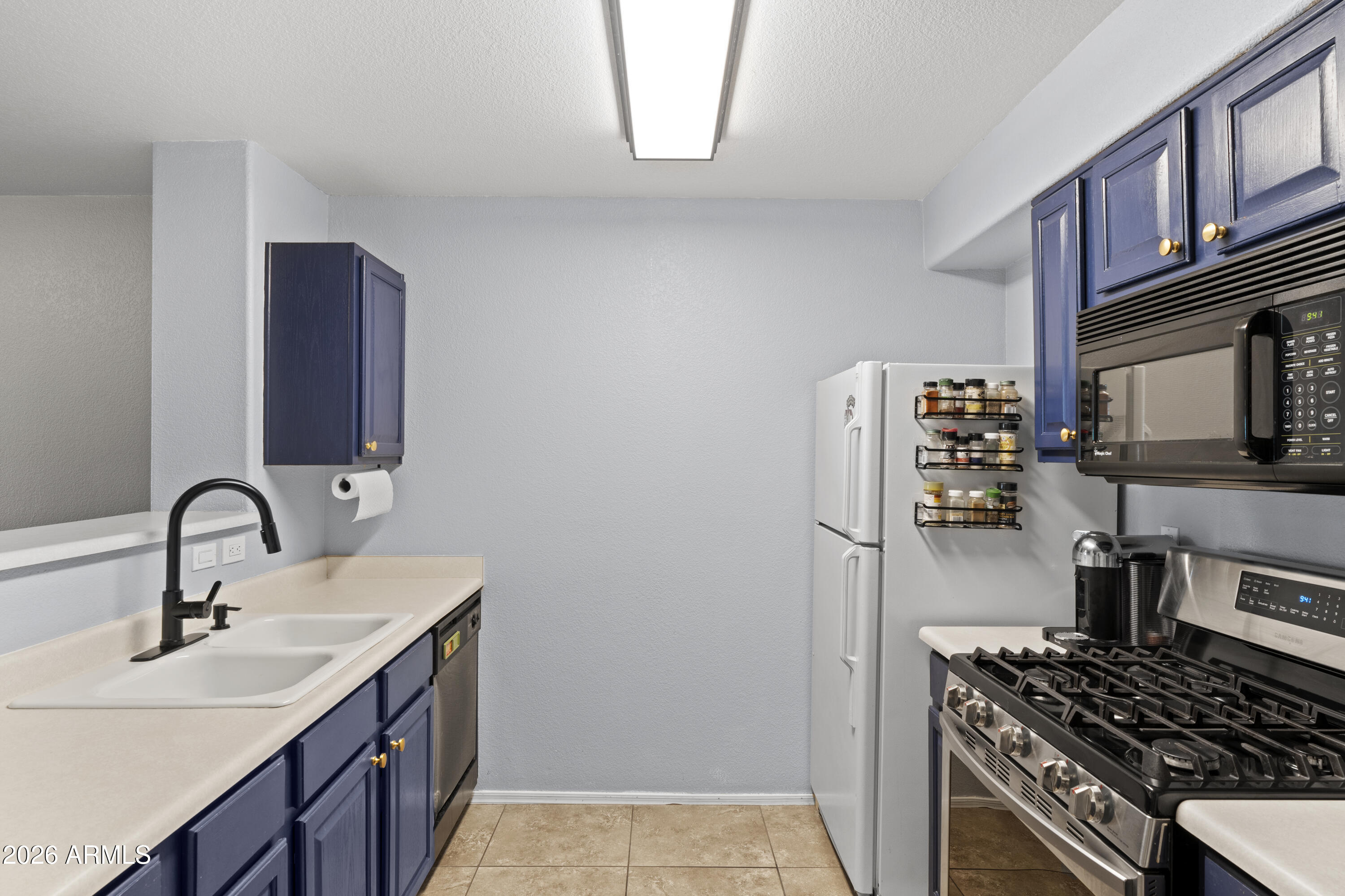 1505 North Center Street, Unit 115 Mesa, AZ 85201 - Photo 3 of 24 a kitchen with a sink and a stove top oven