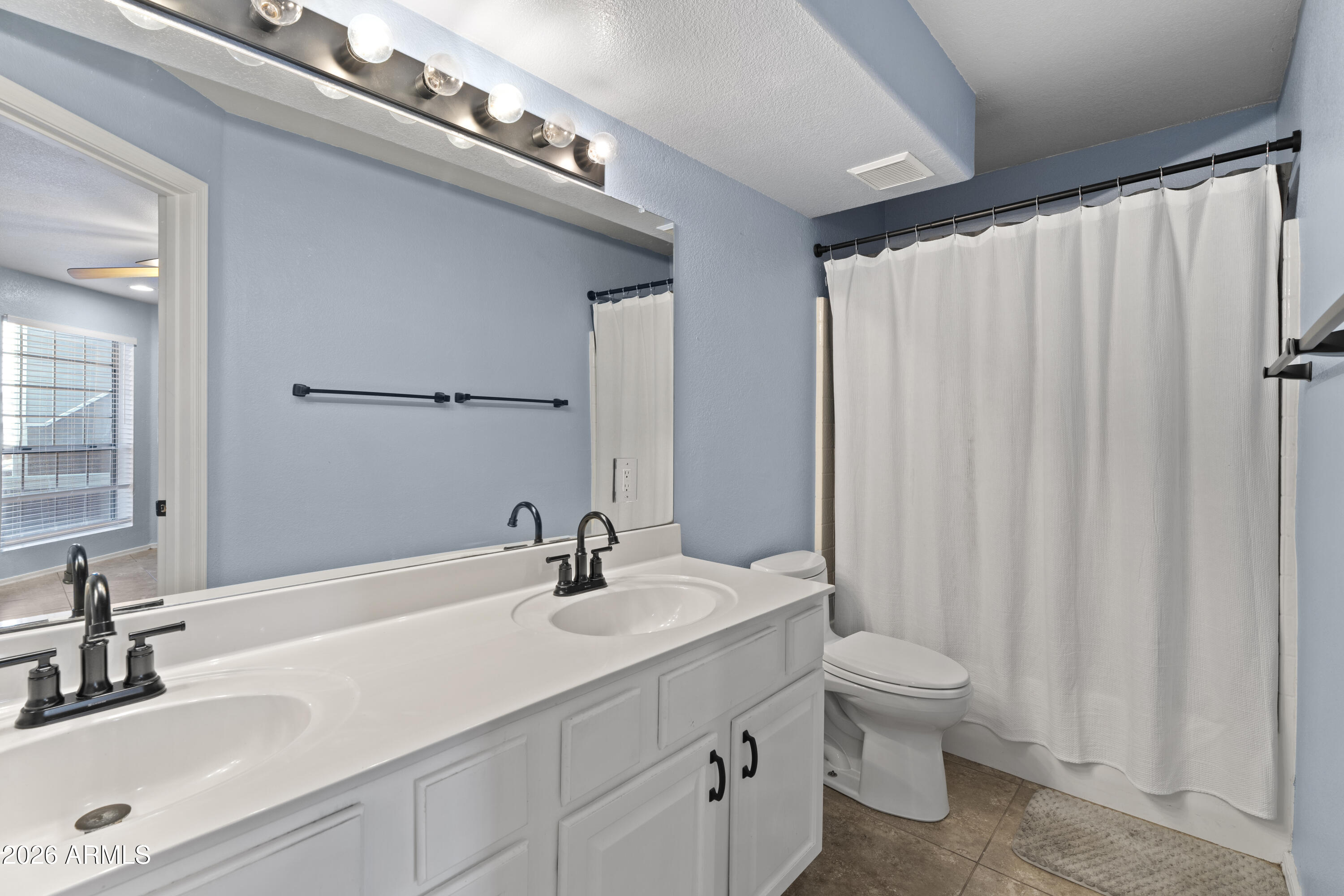 1505 North Center Street, Unit 115 Mesa, AZ 85201 - Photo 9 of 24 a bathroom with a double vanity sink toilet and a mirror