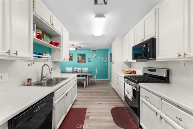 a kitchen with stainless steel appliances a sink dishwasher a stove a microwave and cabinets