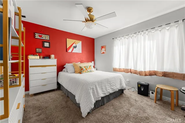 a bedroom with a bed and a ceiling fan
