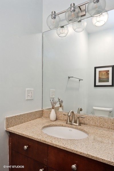 844 East 45th Street Chicago, IL 60653 - Photo 13 of 26 a bathroom with a granite countertop sink and a mirror