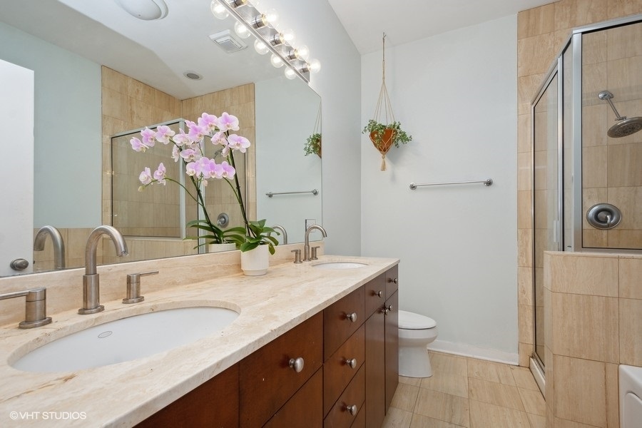 844 East 45th Street Chicago, IL 60653 - Photo 16 of 26 a bathroom with a granite countertop sink a large mirror and a toilet