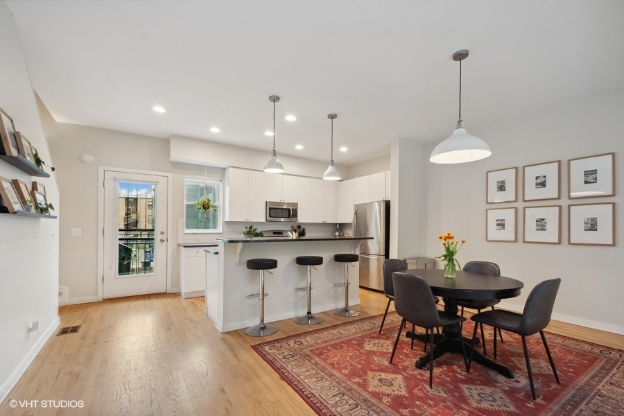 844 East 45th Street Chicago, IL 60653 - Photo 6 of 26 a kitchen with stainless steel appliances kitchen island granite countertop a dining table chairs and white cabinets