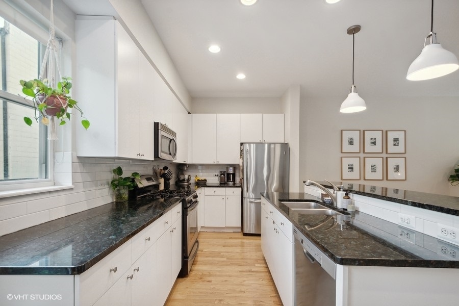 844 East 45th Street Chicago, IL 60653 - Photo 8 of 26 a kitchen with granite countertop a sink a counter top space and stainless steel appliances