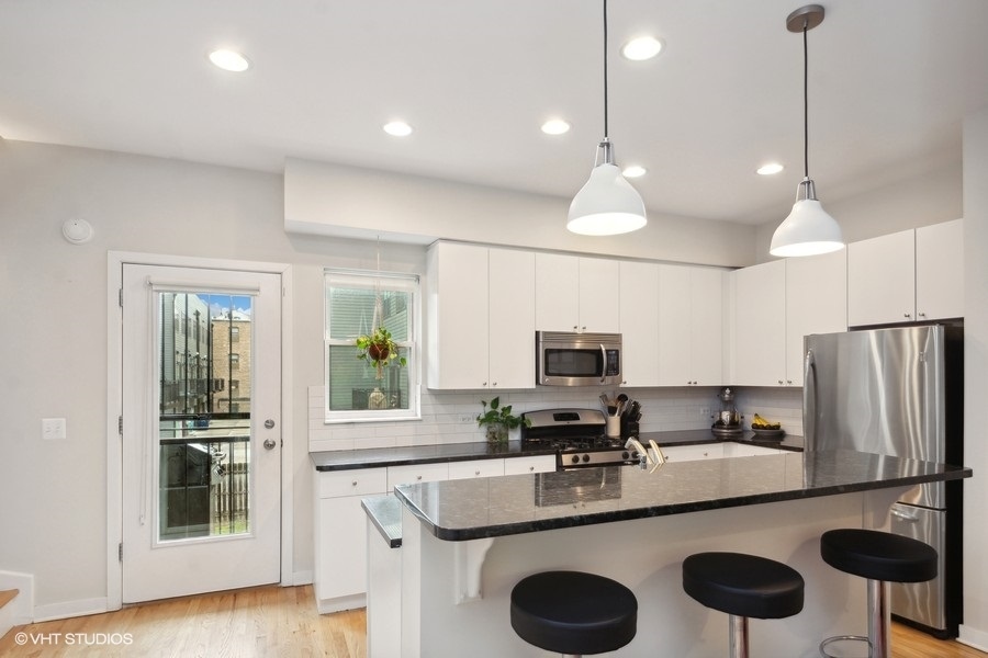 844 East 45th Street Chicago, IL 60653 - Photo 9 of 26 a kitchen with stainless steel appliances granite countertop a sink a stove and refrigerator