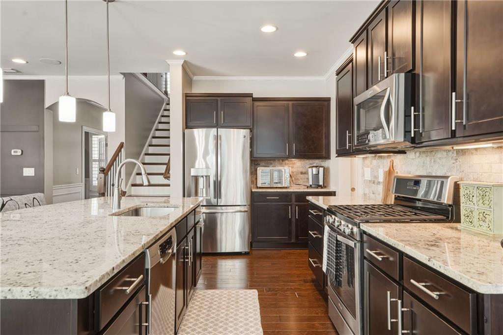 3330 Camelot Way Cumming, GA 30040 - Photo 11 of 47 a kitchen with stainless steel appliances granite countertop a sink a stove and a refrigerator