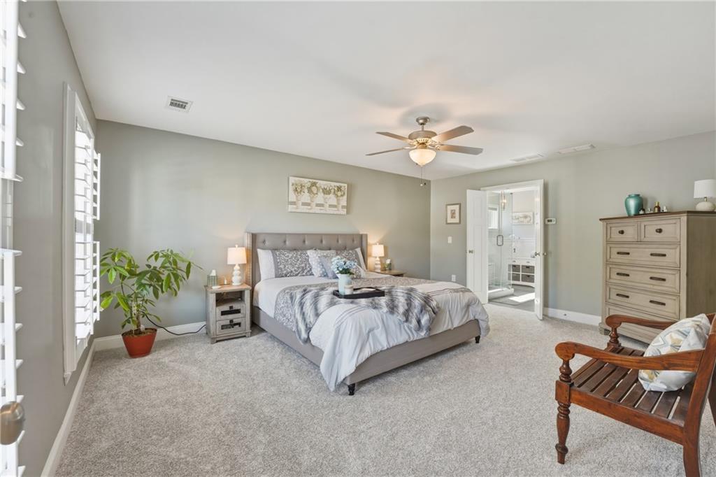 3330 Camelot Way Cumming, GA 30040 - Photo 18 of 47 a spacious bedroom with a bed and a chandelier
