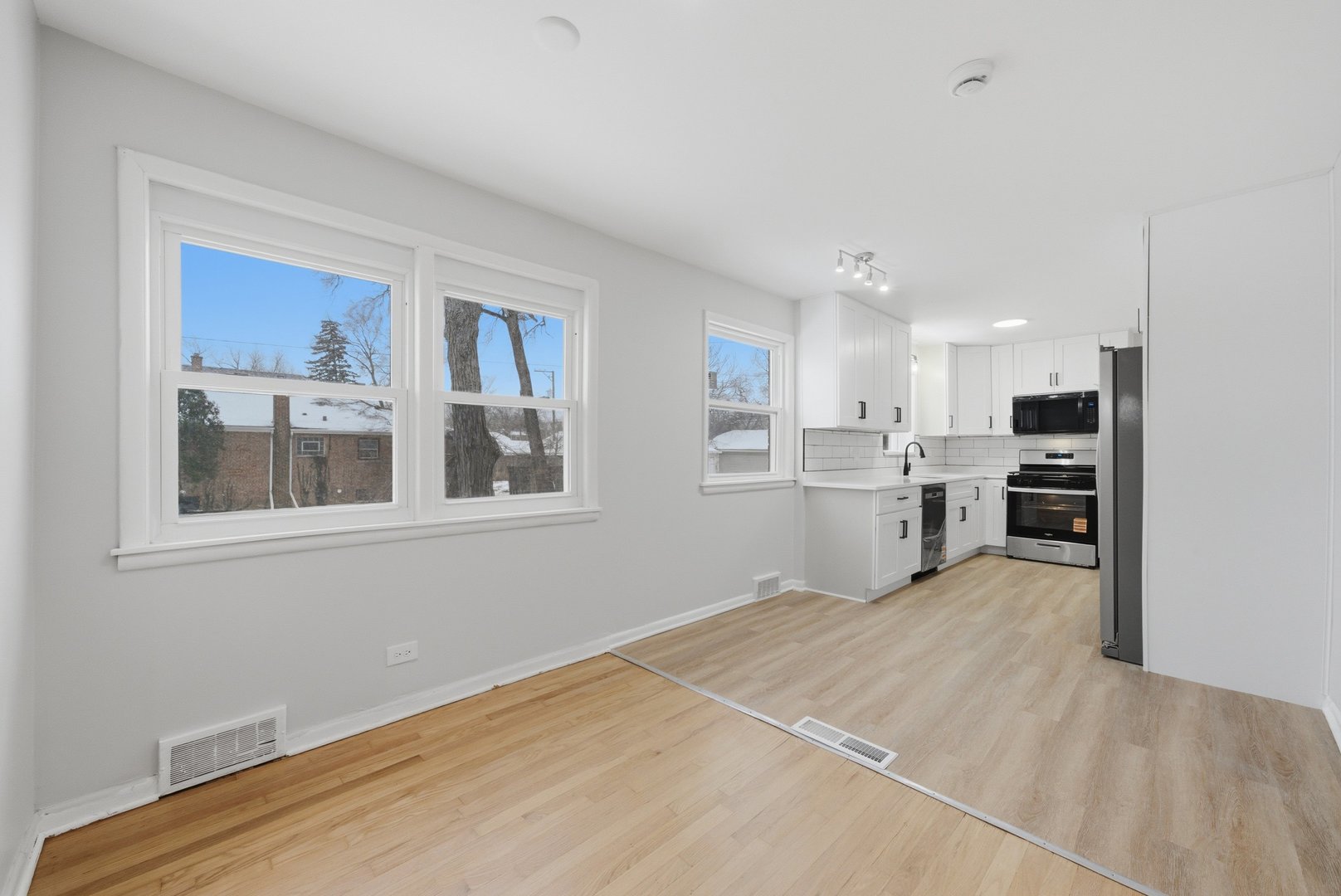 12358 South Lowe Avenue Chicago, IL 60628 - Photo 4 of 14 a view of a kitchen with wooden floor and windows