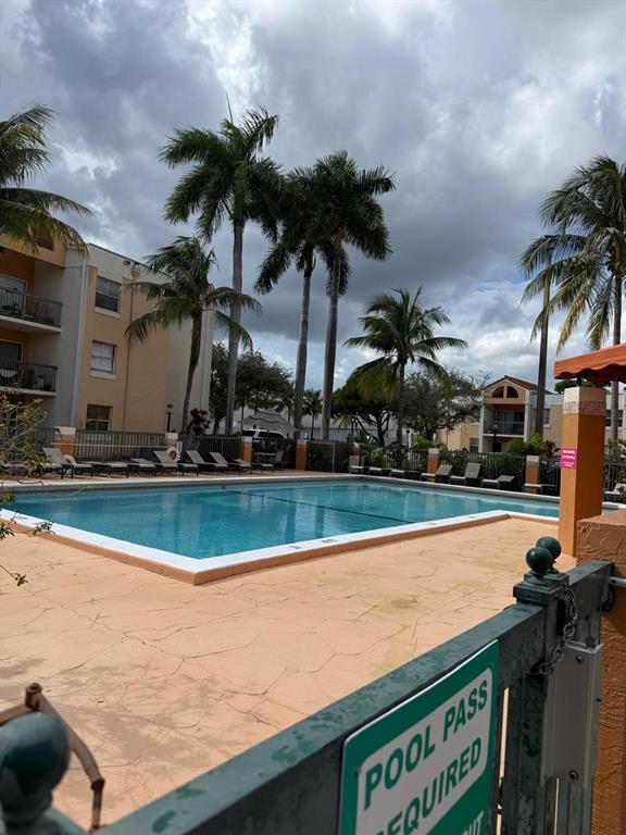 6276 Northwest 186th Street, Unit 310 Hialeah, FL 33015 - Photo 21 of 21 a view of swimming pool with outdoor seating and trees in the background