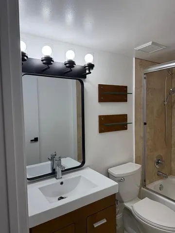 a bathroom with a sink a toilet and shower