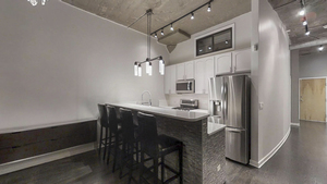 1069 West 14th Place, Unit 123 Chicago, IL 60608 - Photo 4 of 20 a kitchen with stainless steel appliances a table and chairs