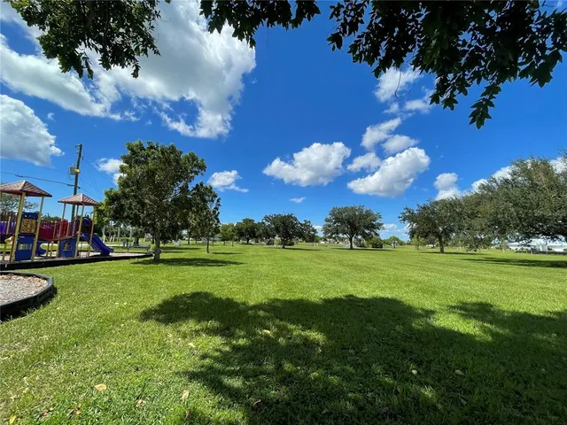 a view of a grassy field with trees around