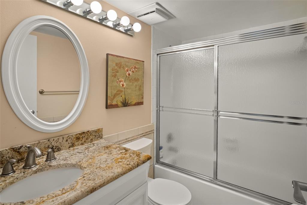 1703 Pelican Cove Road, Unit 356 Sarasota, FL 34231 - Photo 18 of 51 a bathroom with a granite countertop sink mirror vanity and toilet