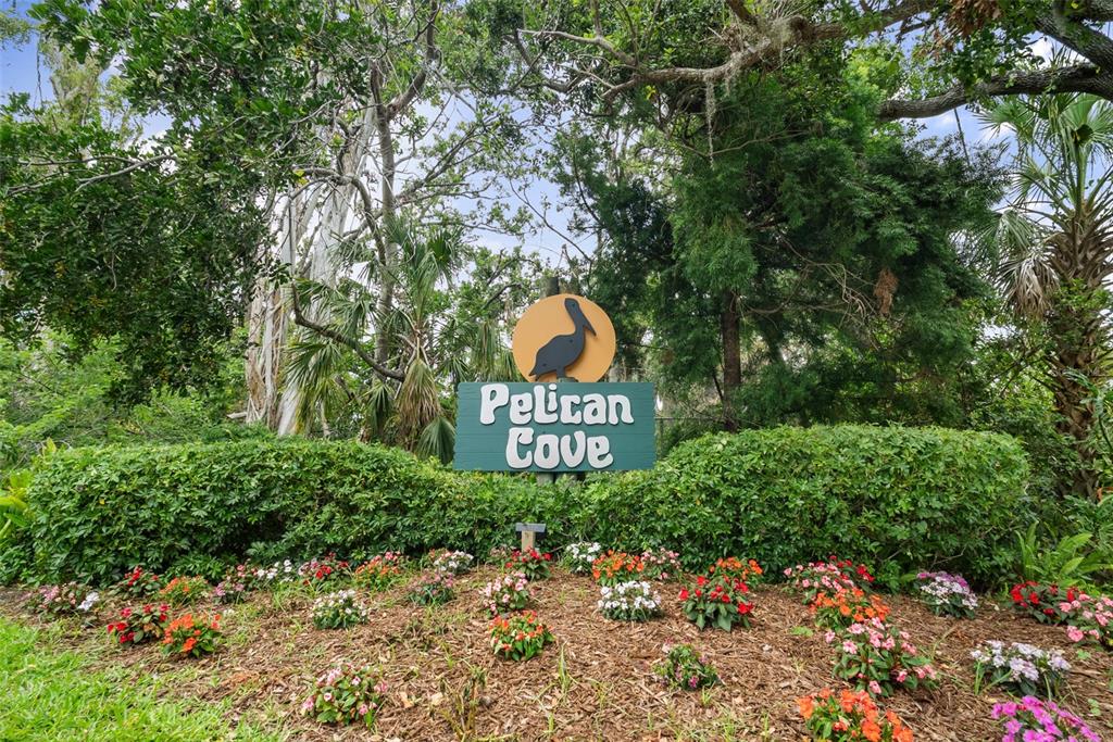1703 Pelican Cove Road, Unit 356 Sarasota, FL 34231 - Photo 2 of 51 a sign that is sitting on a brick wall