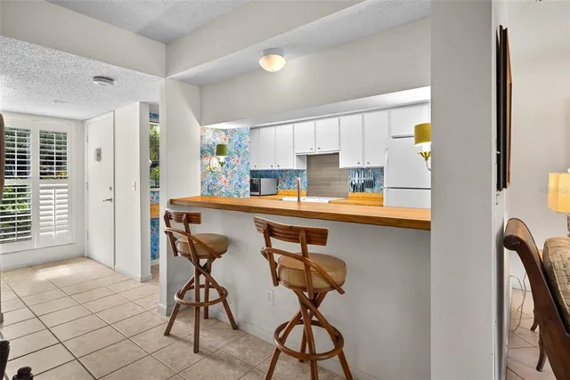 a kitchen with stainless steel appliances kitchen island a table chairs in it and wooden floors